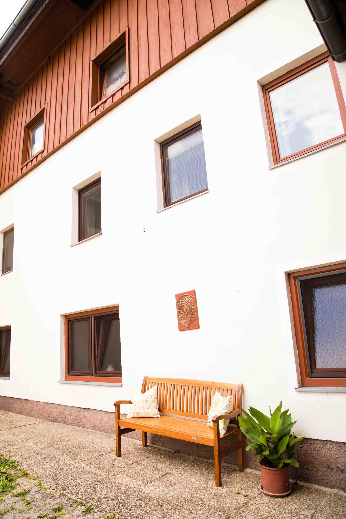 Der Gutshof von der Straße, mit Bank vor dem Haus
